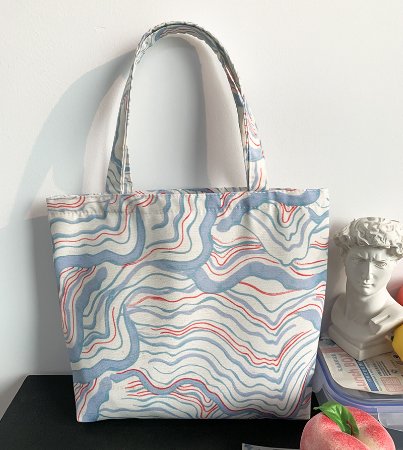 薄藍白曲線ハンドバッグにファスナーがあります。