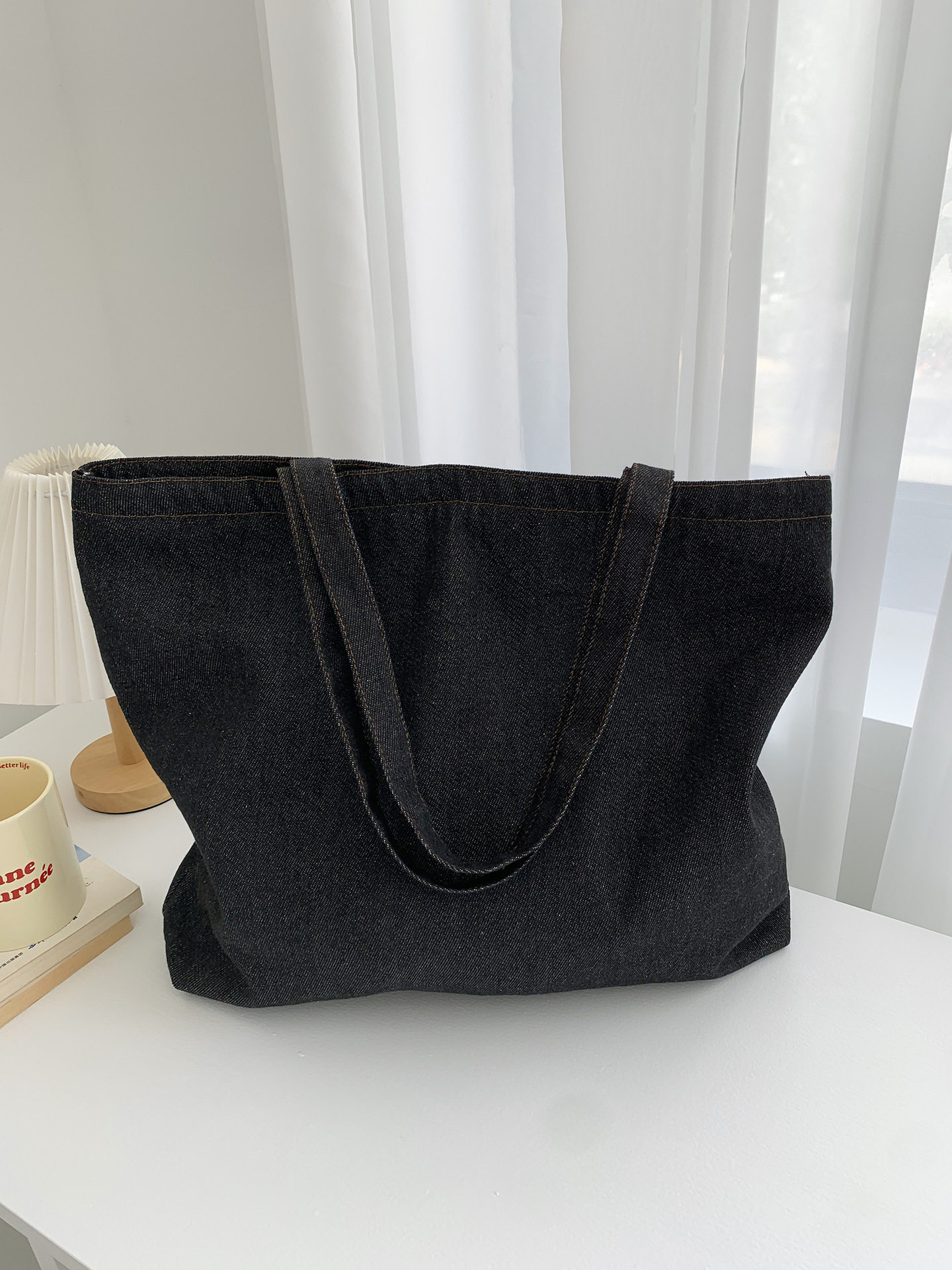 チェック柄の裏地が付いたミディアムブラックのデニムバッグ