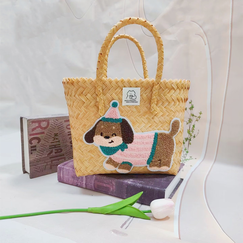 ピンクの縞模様の子犬が付いたベージュのハンドバスケット