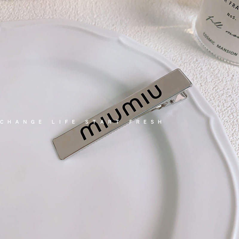 銀色の長方形のmiumiuアヒルのクリップ