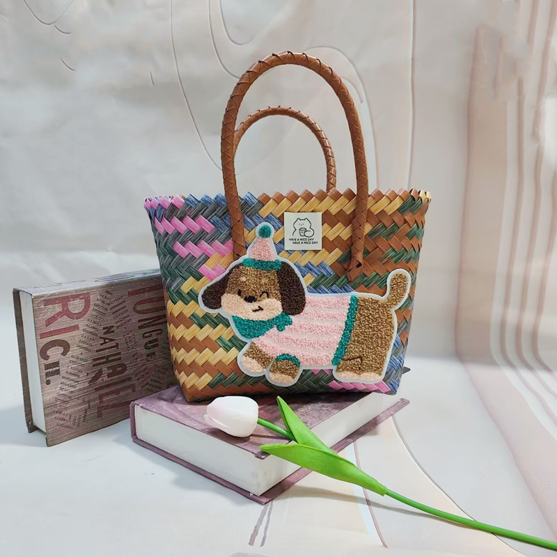 ピンクの縞模様の犬が付いたグレーのハンドバスケット