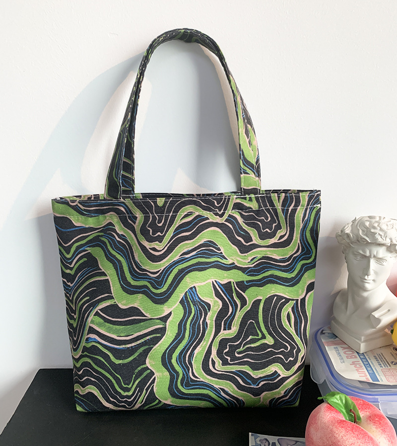 緑黒曲線ハンドバッグにファスナーがある