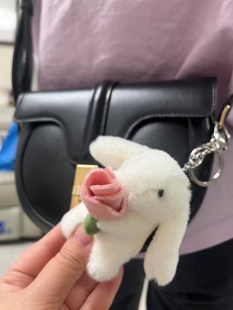 バラのキーホルダーを抱くウサギ