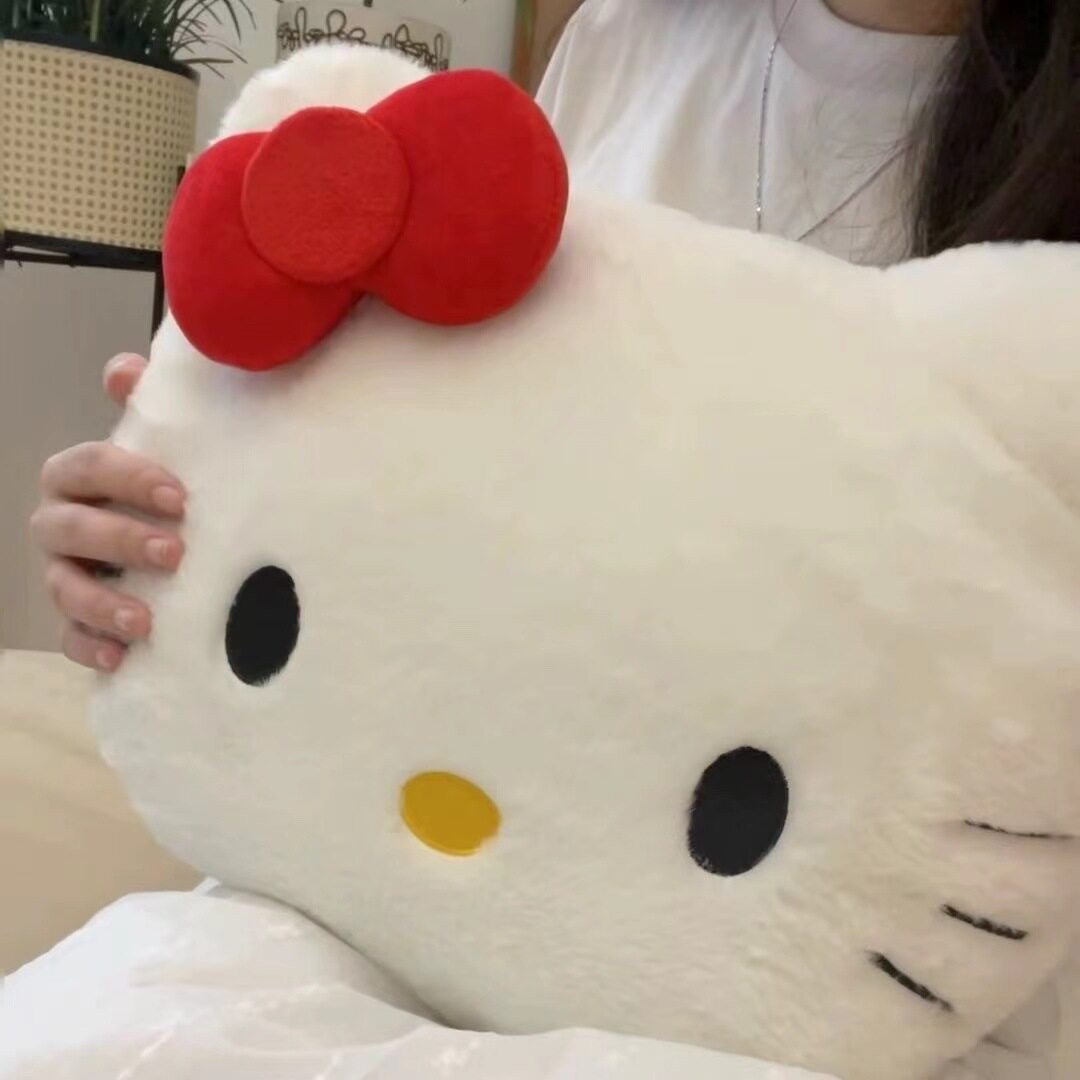 赤い蝶結びの凱凱猫は枕に寄りかかっています。