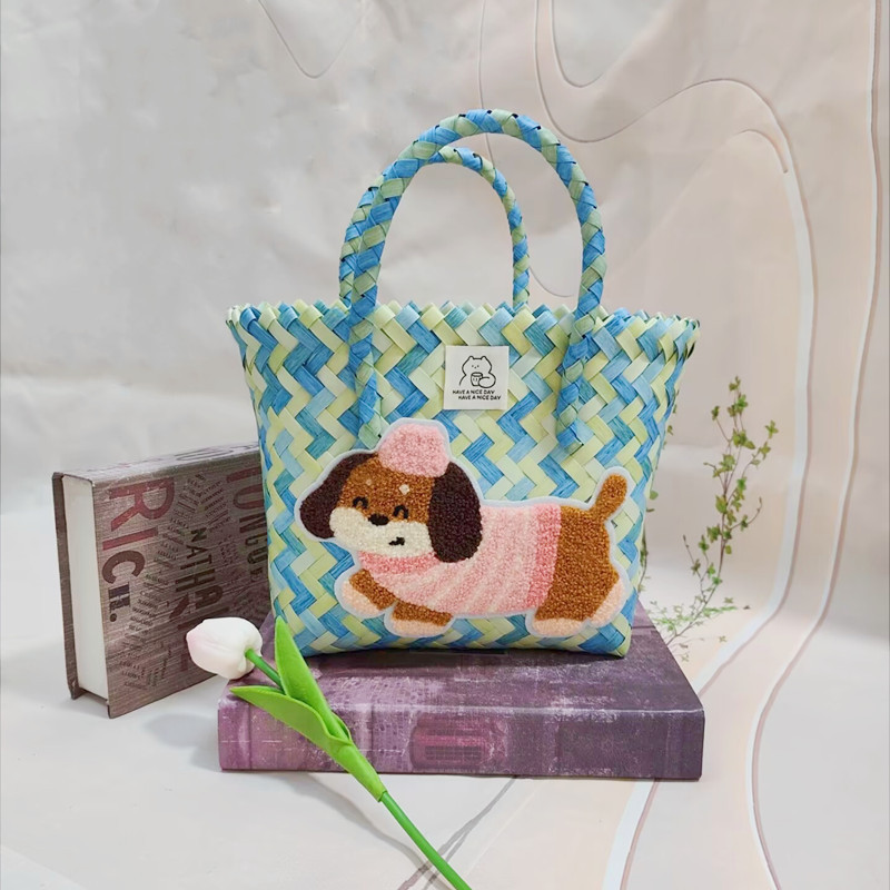 花の緑のハンドバスケットとピンクの帽子の犬